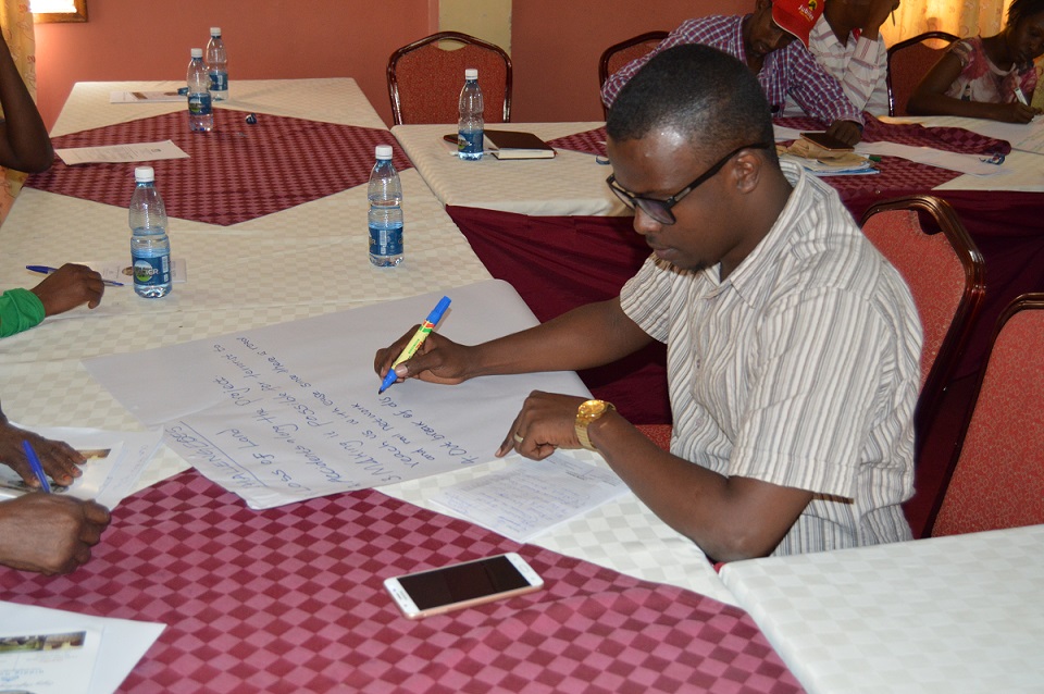 A participant writing notes on Human Rights Based Approaches to planning and budgeting 