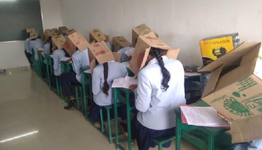 Indian students wear boxes on their heads to prevent cheating during exams